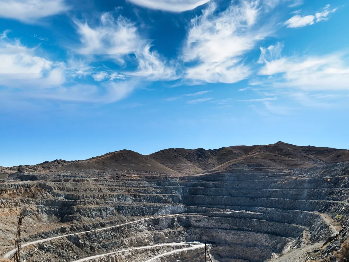 Open-cut mine with terraced walls under a blue sky